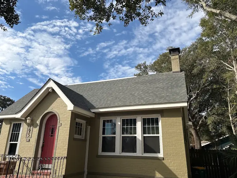 Yellow cottage with a red door and new roof