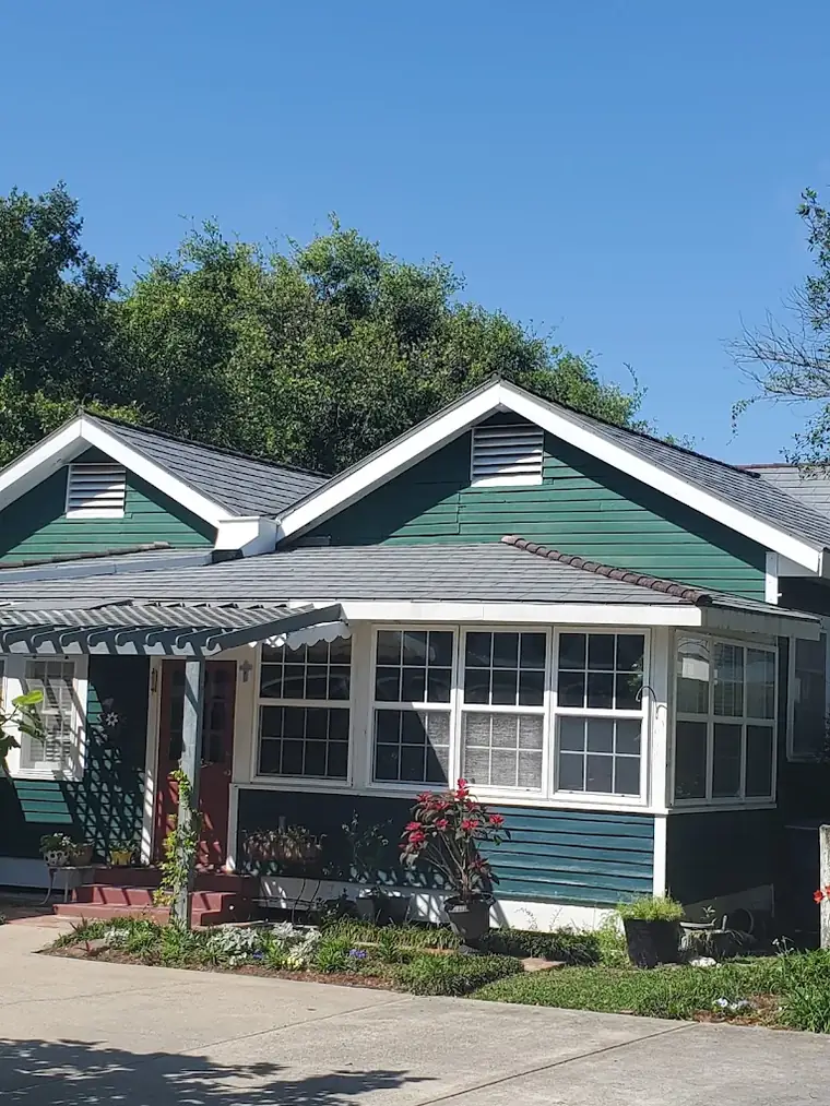 Green craftsman home with porch and new roof